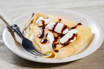 Close up of French style crepe with cream and chocolate sauce