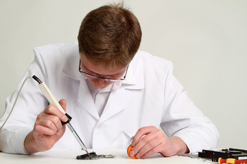 soldering iron in his hand
