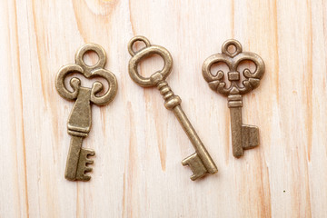 set of three vintage keys on wooden background