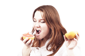 young aggressive girl with grapefruit on white