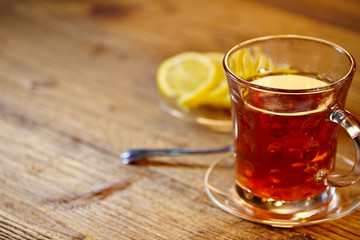 Glass of hot tea on rustic wooden table.
