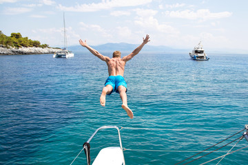 Freiheit, Abenteuer - Mann springt vom Boot aus ins Meer - obrazy, fototapety, plakaty