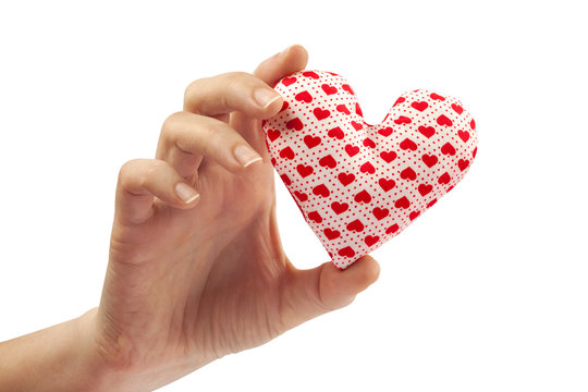Woman hand holds home made stuffed textile white heart