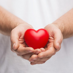 mans cupped hands showing red heart