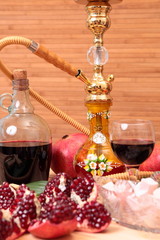 Hookah, bottle of wine and sweets