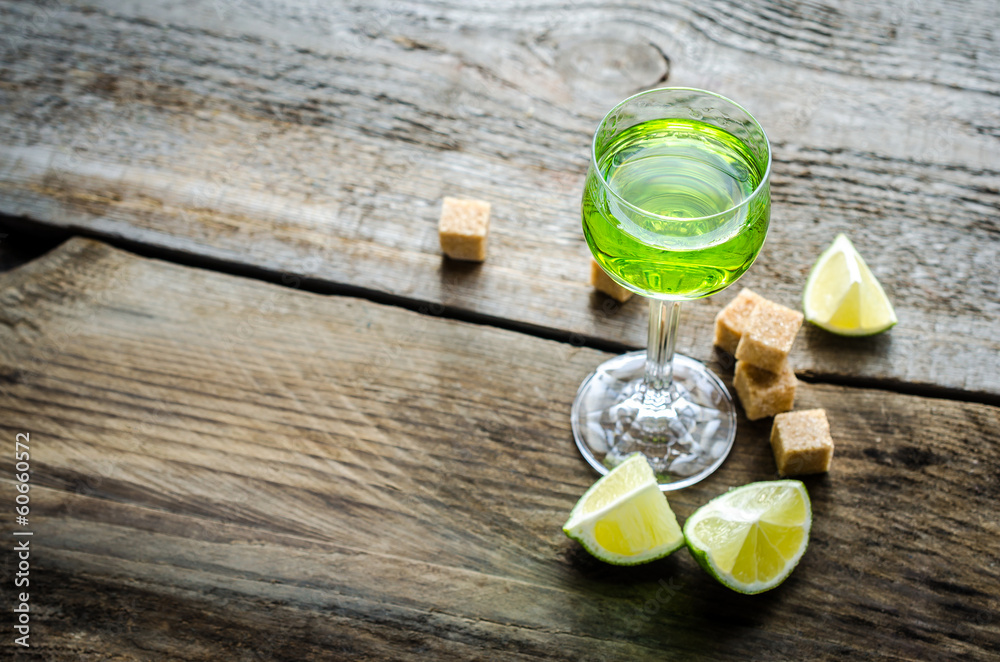 Sticker glass of absinthe with lime and sugar cubes