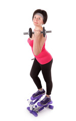 The girl is engaged in fitness with dumbbells on stepper.
