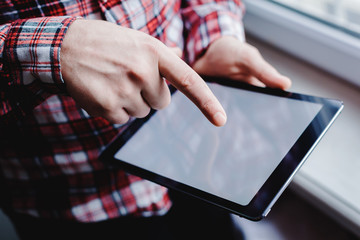 The man uses a tablet PC. Modern gadget in hand.