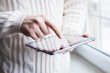 The man uses a tablet PC. Modern gadget in hand.