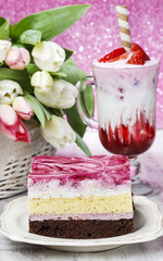 Layer cake with pink icing. Cup of strawberry milkshake decorate