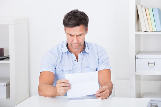 Depressed Man Reading Paper