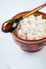 Vertical shot of a wooden khokhloma bowl with cottage cheese