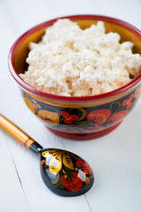 Wooden khokhloma tableware with cottage cheese, close-up