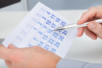 Hand Holding Calendar And Pen