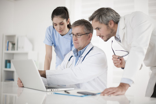 medical team discussing around a computer