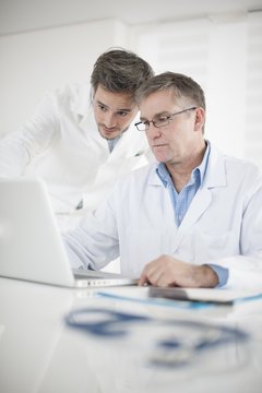 Clinical Director and his assistant discussing around a computer