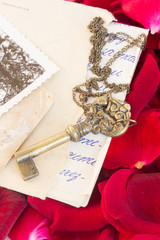 Antique Key with old papers and  rose petals