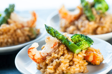 Portion of risotto rice with shrimps and asparagus.