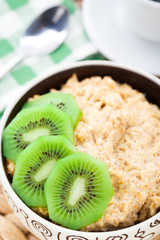 Fototapeta na wymiar Bowl of oats porridge with kiwi