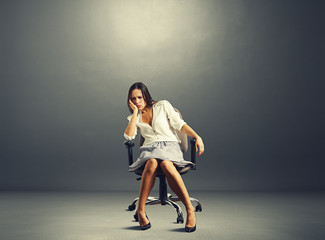 woman sitting on the chair in empty dark room