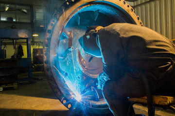 welder working with metal parts. plant repair trucks