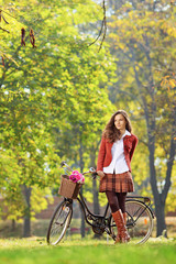 Beautiful female in park with her bicycle