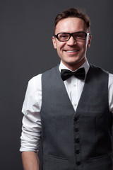 Handsome young man staying against gray wall