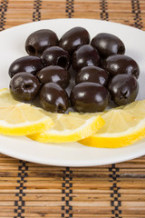 Snack from a lemon and olives on a plate
