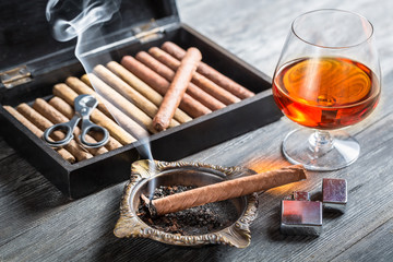Aroma floating up from cigar and cognac in glass