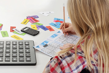 fillette faisant des calculs et sudoku