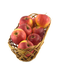 Ripe green and red apples in brown wicker basket isolated