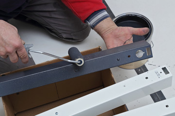 homme peignant luminaire en métal