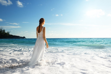 Fototapeta na wymiar young woman standing in sea waves