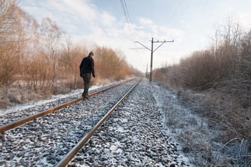 Mężczyzna na torach kolejowych, zima - obrazy, fototapety, plakaty