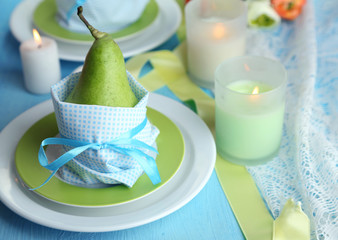 Pears in napkins on plates on wooden table close-up