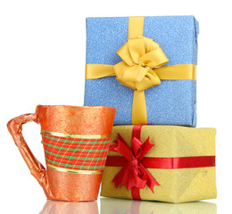 Cup packed in gift paper with gifts isolated on white