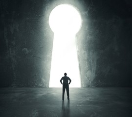 Businessman  looking through key hole