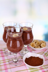 Cocktails with banana and chocolate on table on light