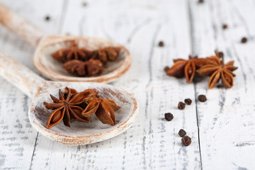Star anise in wooden spoon, on wooden background