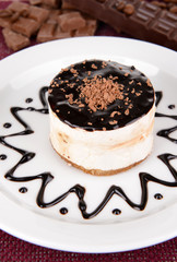 Sweet cake with chocolate on plate on table close-up