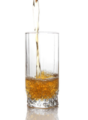 Juice pouring into glass isolated on white