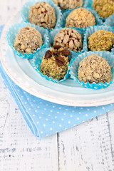 Set of chocolate candies, on plate, on wooden background