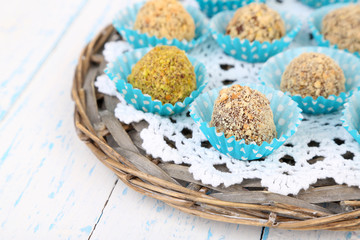 Set of chocolate candies, on wicker mat, on wooden background
