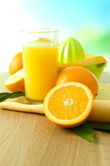 Citrus press and oranges on table on blue background