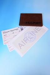 Airline tickets with passport on light blue background