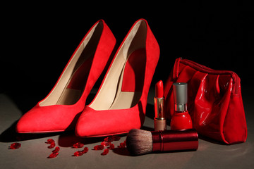 Beautiful red female shoes and cosmetics, on black background