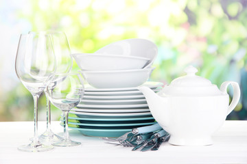 Clean dishes on table on natural background