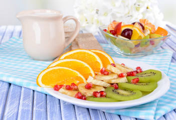 Sweet fresh fruits on plate on table close-up