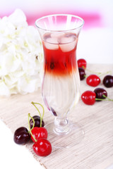 Glass of cocktail on table on light background
