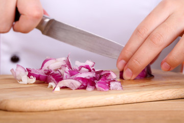 Obraz na płótnie Canvas Female hands cutting bulb onion, close up